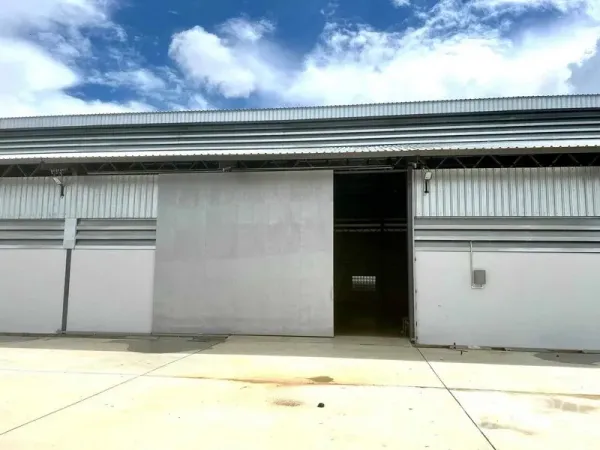 คลังสินค้า ให้เช่าในMueang Samut Prakan, Samut Prakan - ด้านหน้าโกดังสมัยใหม่ ประตูบานเลื่อนโลหะ พร้อมลานคอนกรีตกว้าง ใต้ท้องฟ้าโปร่ง