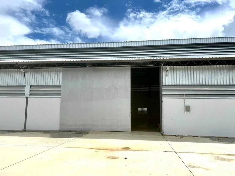 คลังสินค้า ให้เช่าในMueang Samut Prakan, Samut Prakan - ด้านหน้าโกดังสมัยใหม่ ประตูบานเลื่อนโลหะ พร้อมลานคอนกรีตกว้าง ใต้ท้องฟ้าโปร่ง