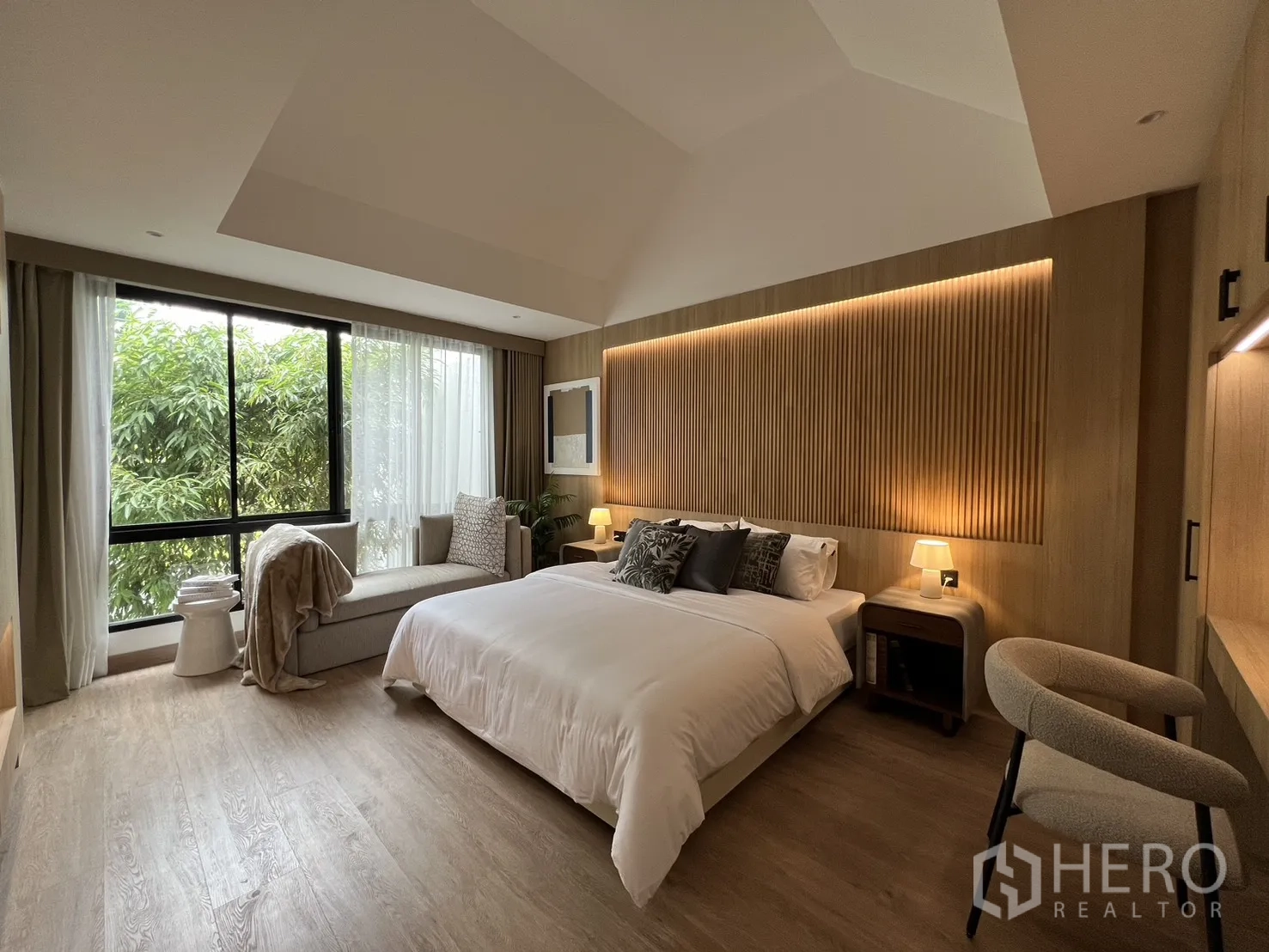 Townhouse for sale in Watthana, Bangkok - Primary bedroom showing wardrobes and built-in desk with warm lighting.