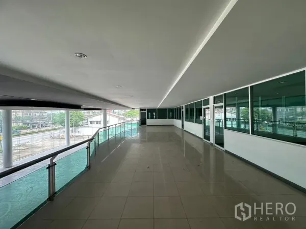 Showroom for rent or sale in Lam Luk Ka, Pathum Thani - Mezzanine corridor with glass railing overlooking the road.
