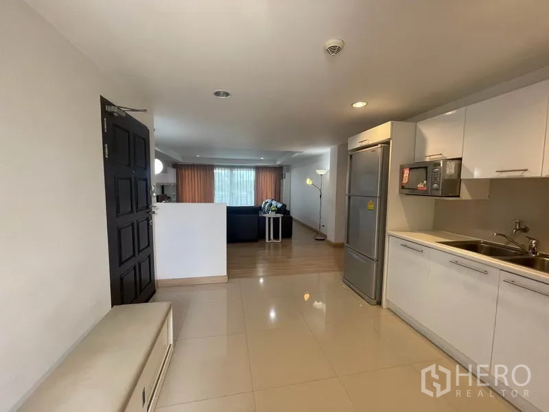 อพาร์ทเมนท์ ให้เช่าในKhlong Toei, Bangkok - โถงทางเข้าและครัวแบบโอเพ่นแปลน เชื่อมต่อสู่ห้องนั่งเล่นที่มีผ้าม่านบานใหญ่