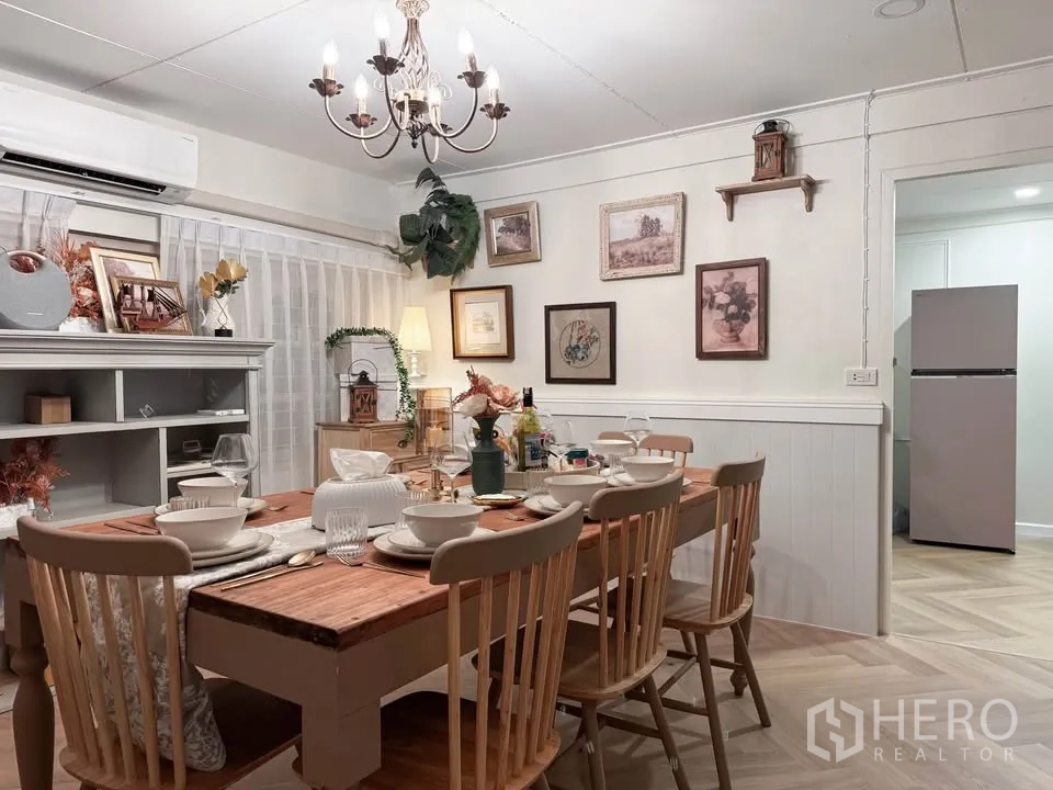 บ้าน ให้เช่าในHuai Khwang, Bangkok - ห้องทานอาหารพร้อมโคมระย้า ชุดโต๊ะไม้ และชั้นวางของ.