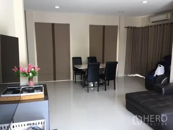 Detached House for rent or sale in Saphan Sung, Bangkok - Another view of the living–dining room with full-length curtains, air-conditioning and recessed lighting.