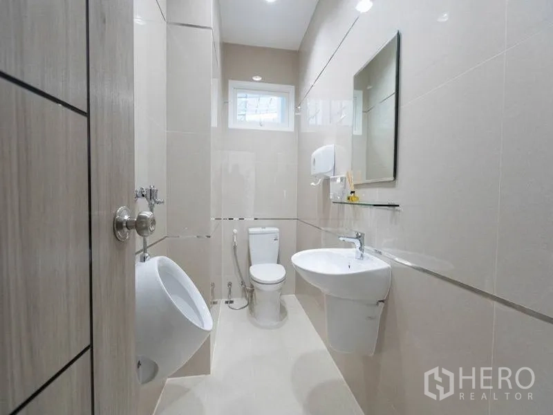 工厂 出租在Bang Bo, Samut Prakan - 整洁的卫浴空间，坐便器、小便斗、洗手盆与镜子并设小窗通风