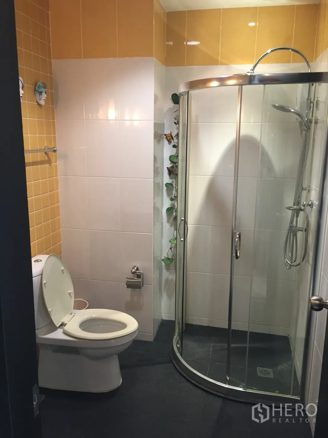 คอนโด ให้เช่าในKhlong Toei, Bangkok - ห้องน้ำผนังกระเบื้องเหลืองขาว พร้อมโถสุขภัณฑ์และตู้ shower กระจกโค้ง.