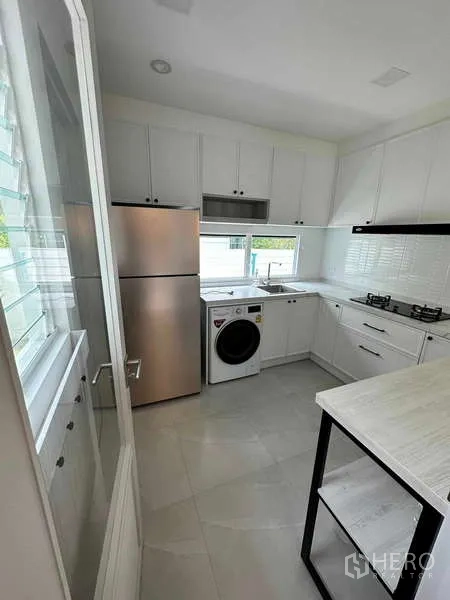 Detached House for sale in Bang Phli, Samut Prakan - Modern white kitchen with gas hob, fridge and washer