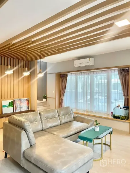 独立式住宅 出租在Prawet, Bangkok - 舒适起居区，大落地窗与吊灯，L型沙发