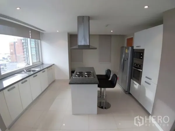 公寓 出租在Watthana, Bangkok - 现代厨房，带岛台灶台、石材台面、嵌入式烤箱与城市景观窗。