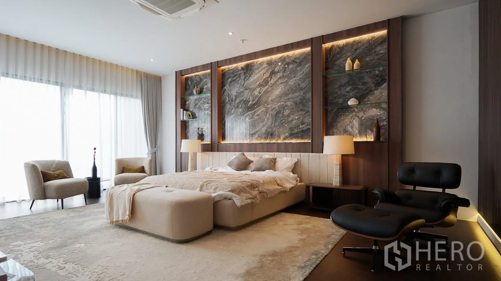 独立式住宅 出租或出售在Bang Kapi, Bangkok - 主卧套房，特大床、休闲椅与暖色灯带。