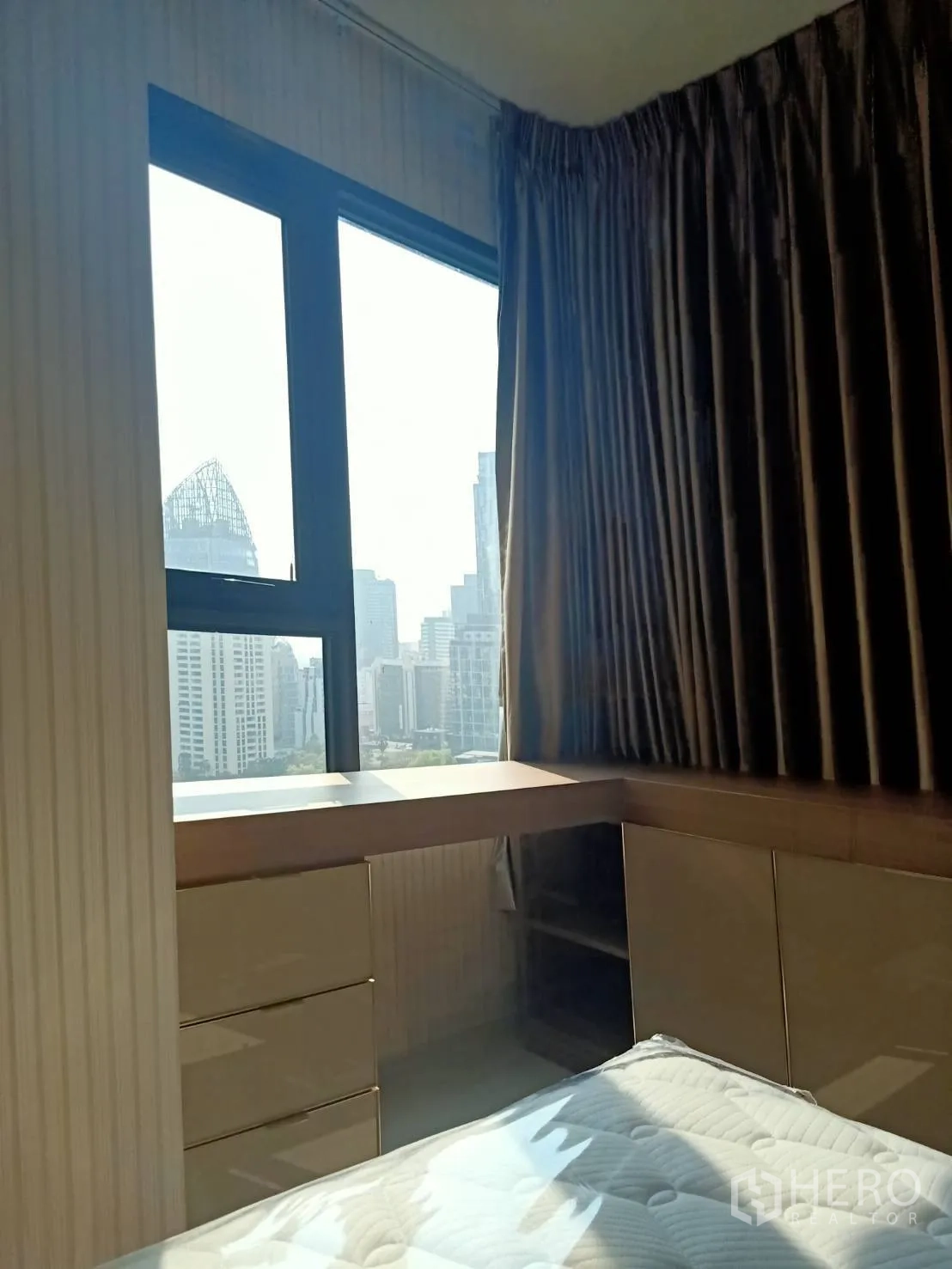 公寓 for rent in Pathum Wan, Bangkok - 卧室带转角书桌与抽屉，大窗俯瞰城市天际线。