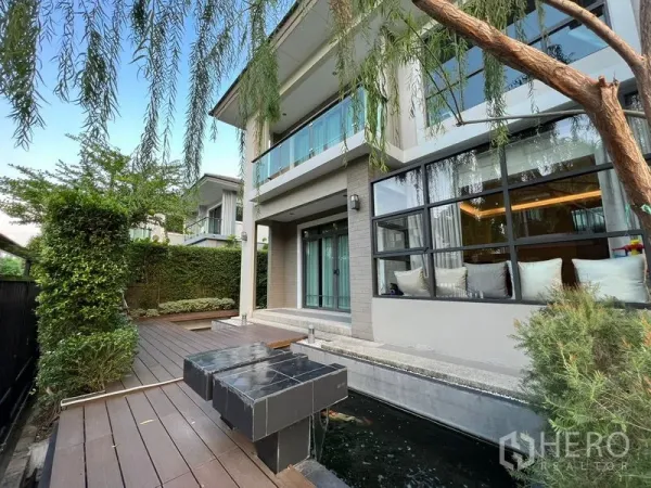 Detached House for rent in Suan Luang, Bangkok - Side garden with timber deck, koi pond and large house windows.