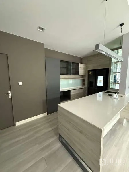 Detached House for rent or sale in Bang Bua Thong, Nonthaburi - Kitchen angle showing built-in cabinets, tall fridge space, and sleek island.