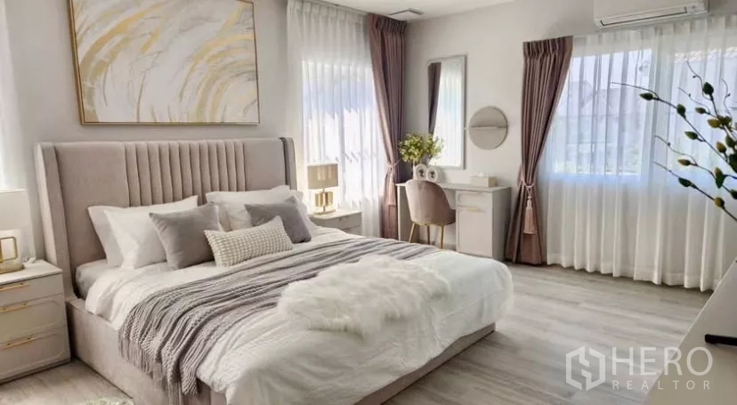 Detached House for rent in Bang Phli, Samut Prakan - Master bedroom with upholstered headboard, desk and large windows.