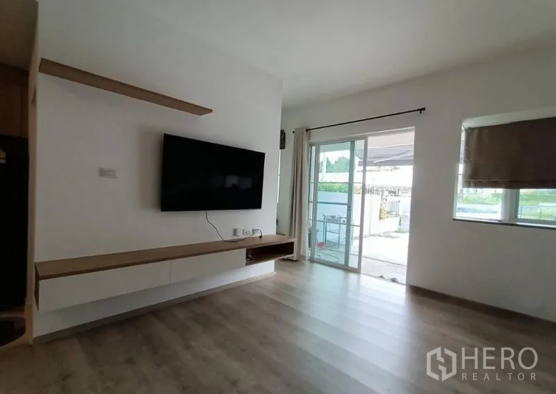 ทาวน์เฮาส์ ให้เช่าในPrawet, Bangkok - ห้องนั่งเล่นสว่าง ติดทีวีผนัง ชั้นลอย และประตูกระจกบานเลื่อนไปยังลานหลังบ้าน