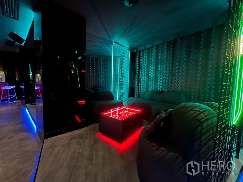 零售空间 出租在Ratchathewi, Bangkok - 舒适角落，弧形沙发与发光红色方形茶几。