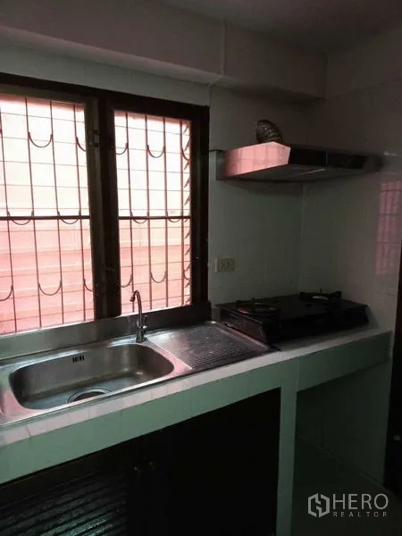 ทาวน์เฮาส์ ให้เช่าในKhlong Toei, Bangkok - มุมเตรียมอาหารพร้อมอ่างล้างจาน เตาแก๊ส และหน้าต่างเหล็กดัด