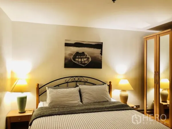 คอนโด ให้เช่าในPathum Wan, Bangkok - ห้องนอนหลักอบอุ่น เตียงคู่ โคมไฟหัวเตียง และตู้เสื้อผ้าบานกระจก