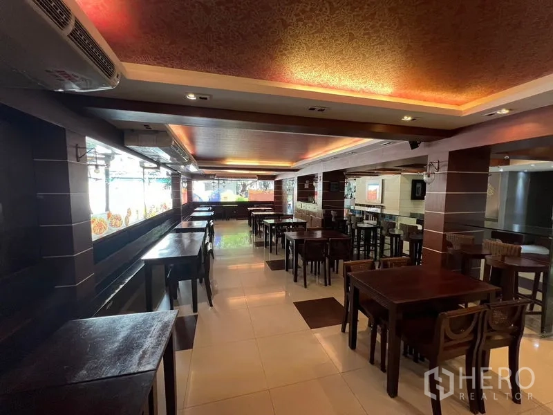 零售空间 出租或出售在Khlong Toei, Bangkok - 采光良好的用餐区，大窗、餐桌与吧台，适合餐厅经营。