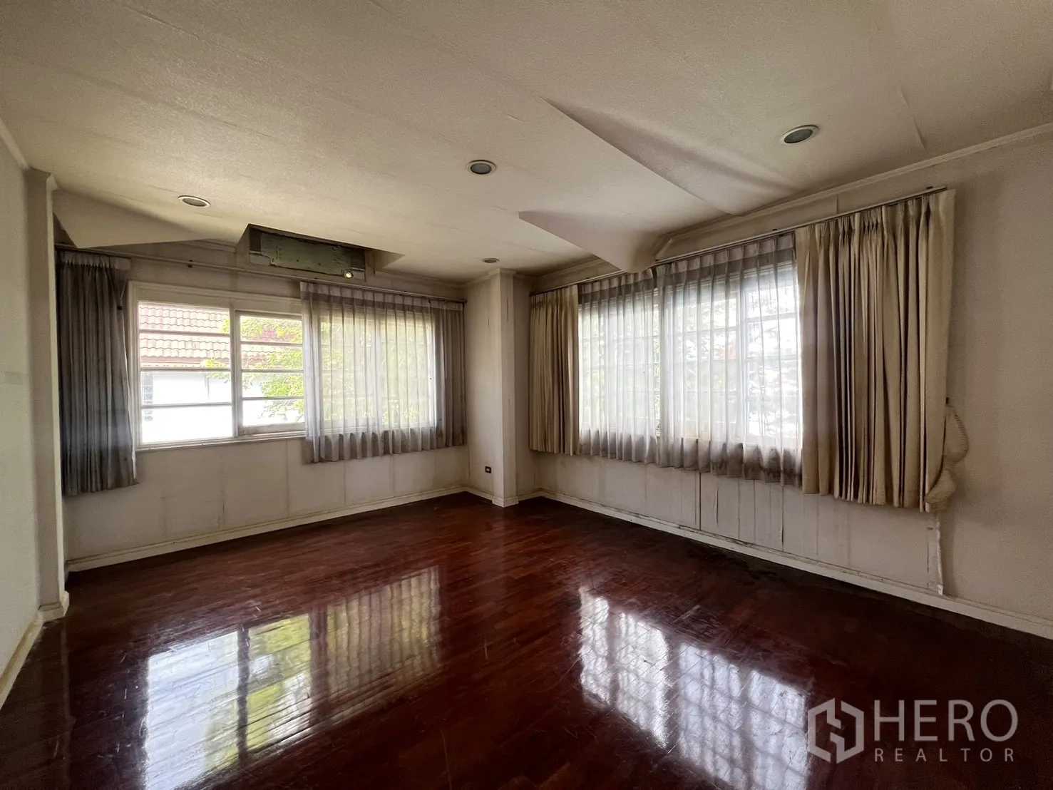 Detached House for sale in Saphan Sung, Bangkok - Corner room with multiple windows, sheer curtains, and wood floors.