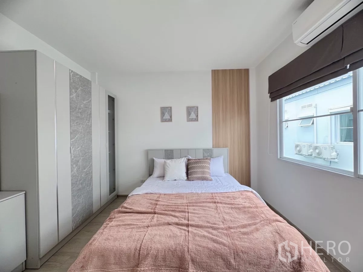 联排别墅 出租在Prawet, Bangkok - 次卧设床、衣柜、空调与窗户采光。