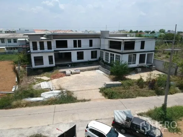 Land for sale in Phra Nakhon Si Ayutthaya, Phra Nakhon Si Ayutthaya - Street‑facing facade of the unfinished low‑rise structure with wide concrete forecourt and direct road access.