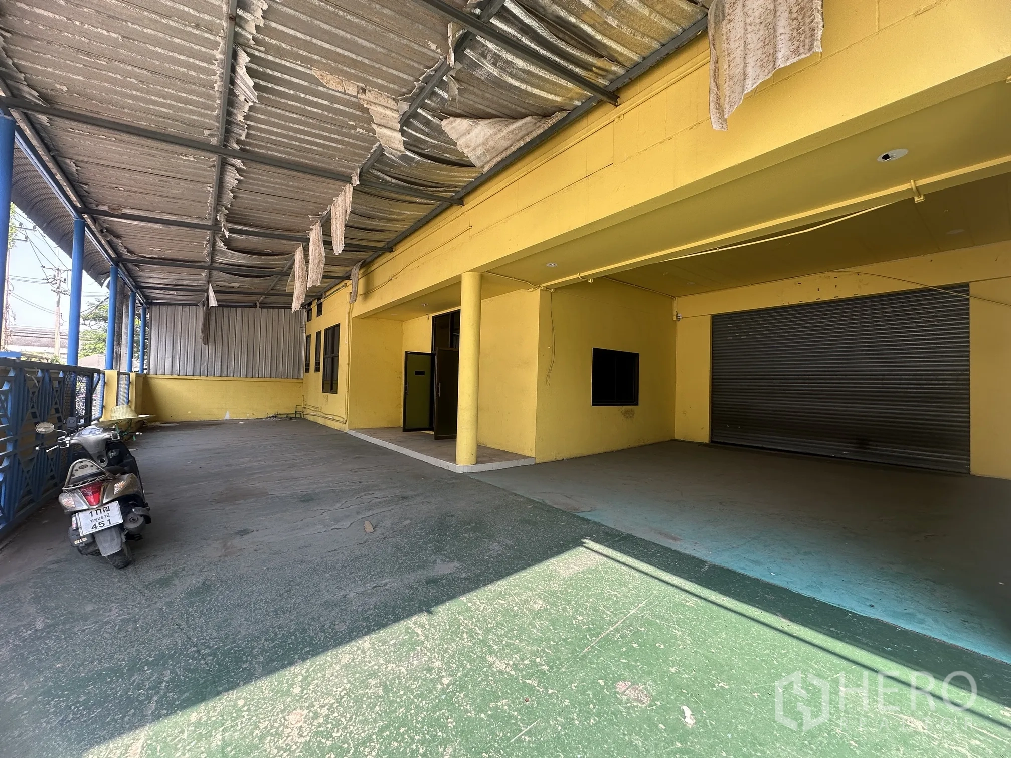 โรงงาน for rent in Lat Lum Kaeo, Pathum Thani - พื้นที่โหลดสินค้ามีหลังคากระเบื้องลอน เสา และประตูม้วนขนาดใหญ่