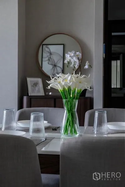 คอนโด ให้เช่า - โต๊ะอาหารจัดเซ็ตพร้อมแก้วน้ำและแจกันดอกลิลลี่สีขาว