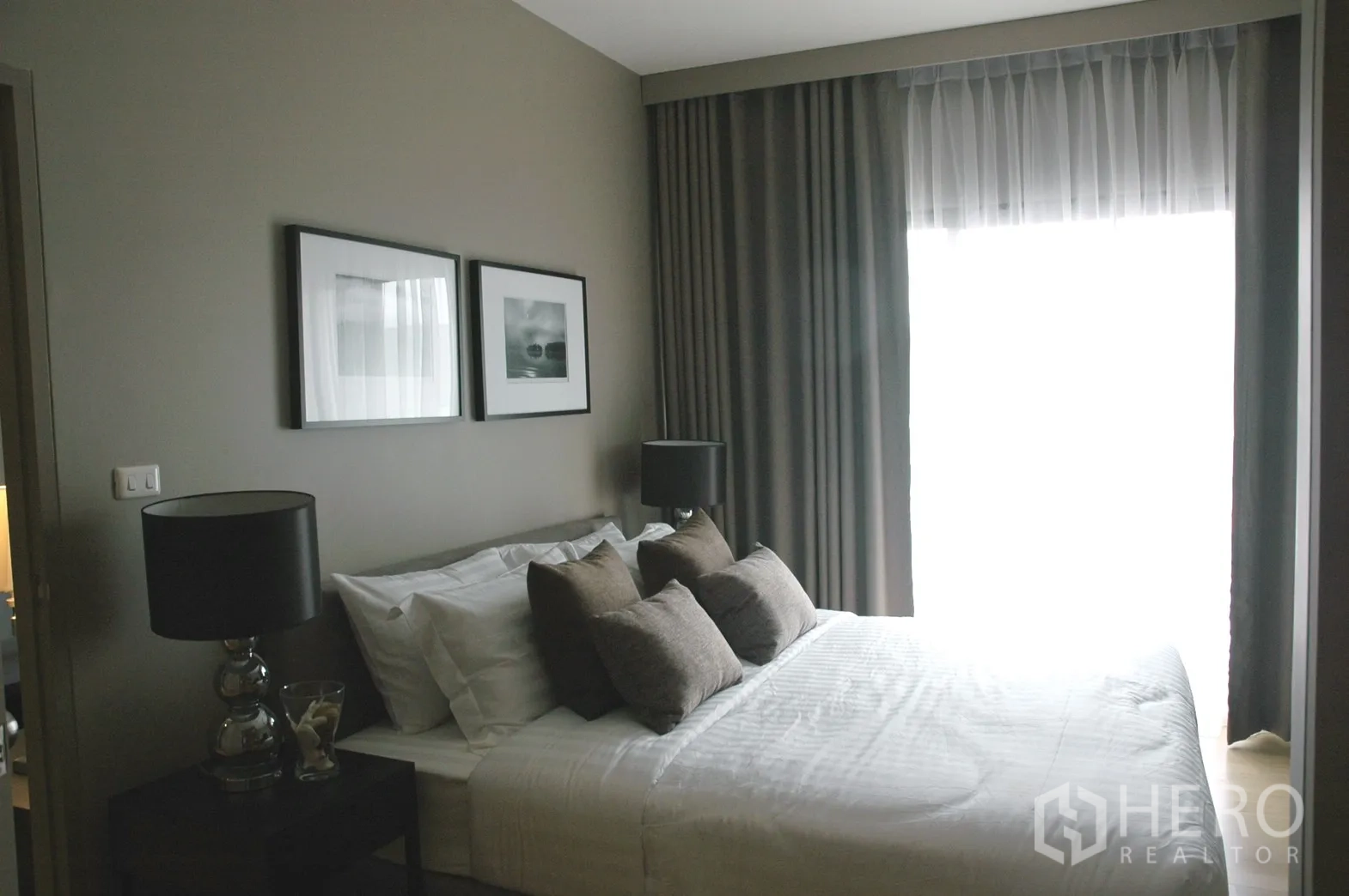 Condominium for rent in Watthana, Bangkok - Bright bedroom with double bed, layered blackout and sheer curtains, and framed artwork.