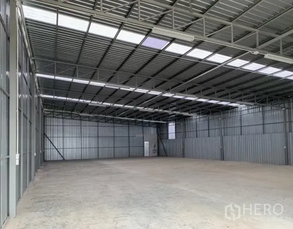 货栈 出租在Mueang Pathum Thani, Pathum Thani - 仓库内部，高钢桁架屋顶、采光板与混凝土地面。