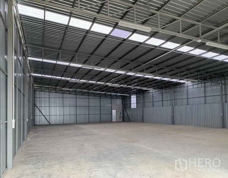 货栈 出租在Mueang Pathum Thani, Pathum Thani - 仓库内部，高钢桁架屋顶、采光板与混凝土地面。