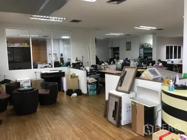 Warehouse for rent in Khlong Sam Wa, Bangkok - Open-plan office area inside the warehouse with desks, glass partition and fluorescent lighting.