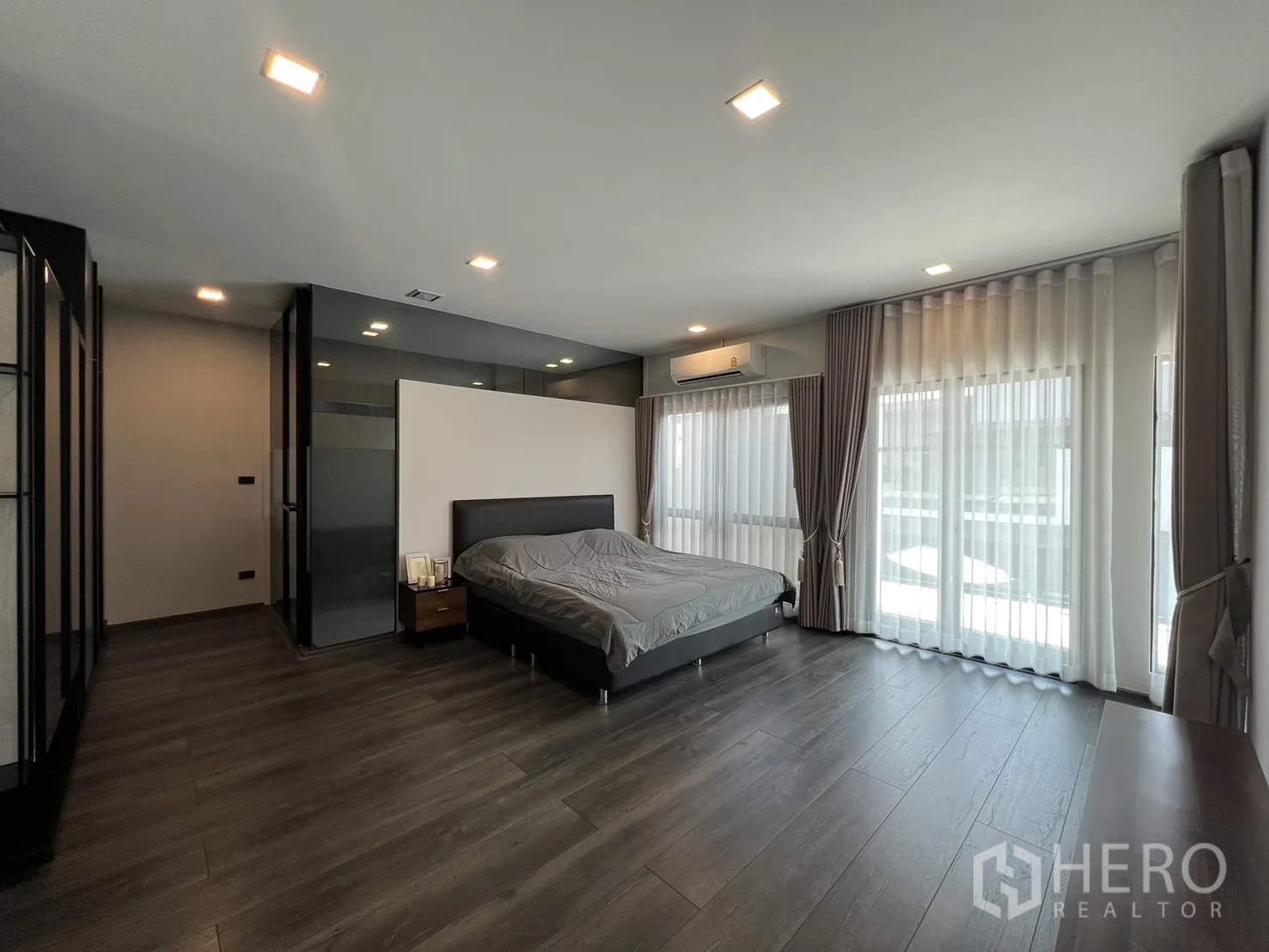 Detached House for rent in Bang Phli, Samut Prakan - Large master bedroom with floor-to-ceiling windows, curtains and wood floors.