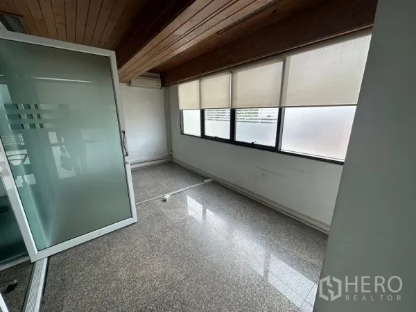 Office Space for rent - Bright office room with frosted sliding door, timber ceiling, roller blinds and long windows.