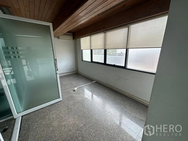 Office Space for rent - Bright office room with frosted sliding door, timber ceiling, roller blinds and long windows.