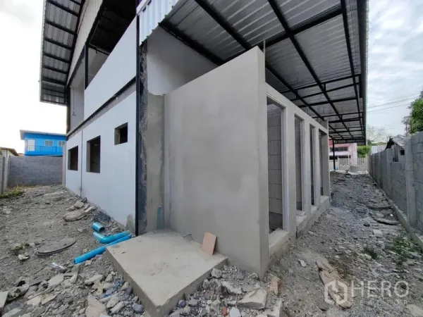 Factory for rent or sale in Mueang Samut Prakan, Samut Prakan - Exterior view of unfinished restroom block under a side canopy beside the factory.