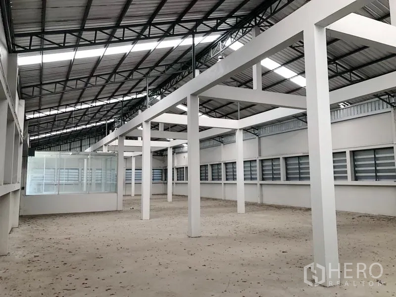 工厂 出租在Bang Bua Thong, Nonthaburi - 生产大厅设百叶窗、白色立柱及转角办公室。