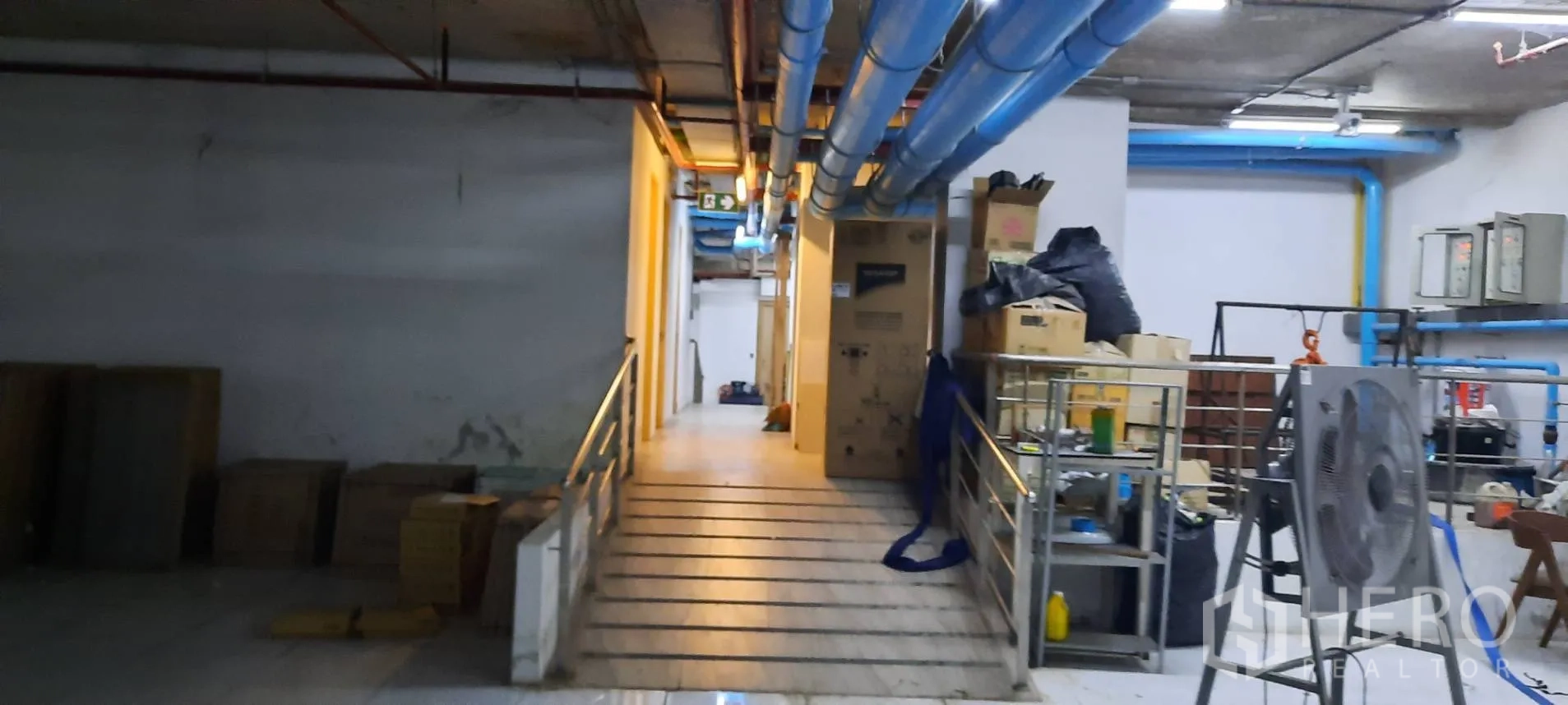พื้นที่ขายของ for rent in Watthana, Bangkok - โถงบริการพร้อมทางลาด ท่อสาธารณูปโภคสีน้ำเงิน และชั้นวางอุปกรณ์