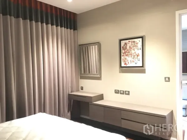 คอนโด ให้เช่าในWatthana, Bangkok - มุมมองห้องนอนพร้อมตู้บิวท์อินยาว โต๊ะเครื่องแป้ง ภาพแขวน และผ้าม่านเต็มบาน