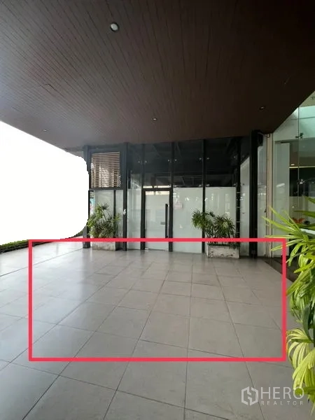 พื้นที่ขายปลีก ให้เช่า - พื้นที่หน้าร้านกึ่งเอาต์ดอร์ พื้นกระเบื้อง หน้ากระจกเต็มบาน มีต้นไม้ประดับ บริเวณทางเข้าอาคารย่านเอกมัย