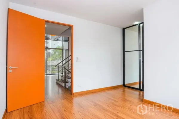 联排别墅 出租在Watthana, Bangkok - 卧室，木地板，橙色门与玻璃隔断