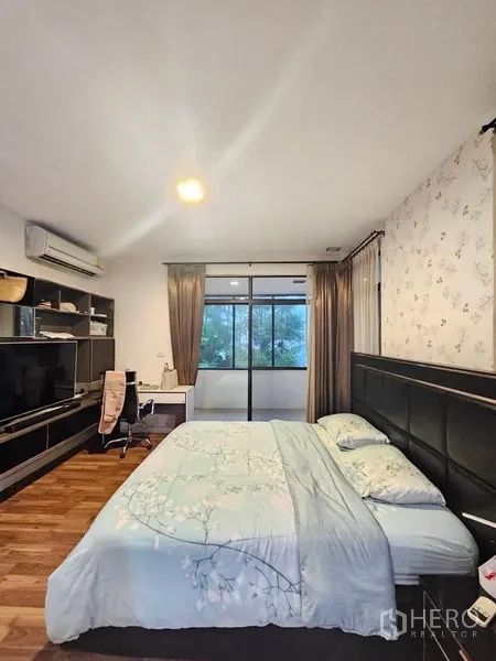 Detached House for sale in Prawet, Bangkok - Alternate view of master bedroom showing TV console, work desk and sliding glass to balcony.