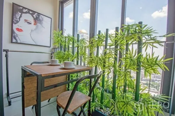 คอนโด ขายในRatchathewi, Bangkok - ระเบียงกระจกพร้อมชุดโต๊ะบิสโทร ต้นไม้กระถาง และวิวสกายไลน์