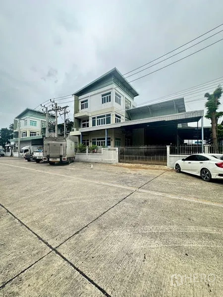 คลังสินค้า ให้เช่าหรือขายในLam Luk Ka, Pathum Thani - ภาพถนนกว้าง เห็นเขตรั้วโกดังและอาคารข้างเคียง