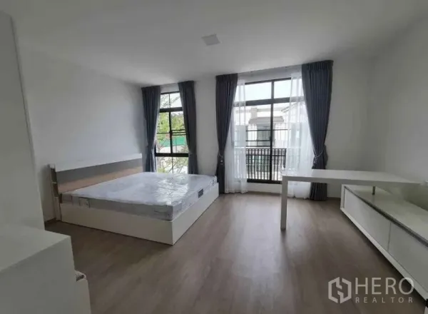 ทาวน์เฮาส์ ให้เช่าในBang Phli, Samut Prakan - ห้องนอนกว้าง หน้าต่างสูงจรดเพดาน ผ้าม่านโปร่ง เตียงและโต๊ะทำงาน