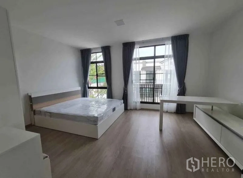 ทาวน์เฮาส์ ให้เช่าในBang Phli, Samut Prakan - ห้องนอนกว้าง หน้าต่างสูงจรดเพดาน ผ้าม่านโปร่ง เตียงและโต๊ะทำงาน