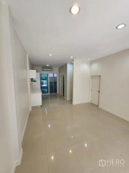 Townhouse for rent in Wang Thonglang, Bangkok - Long open-plan living and dining area with recessed lights and a pantry zone.