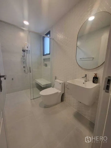 บ้าน ให้เช่าในSaphan Sung, Bangkok - ห้องน้ำโทนขาว มีกระจกกั้นอาบน้ำและอ่างล้างหน้าแขวนผนัง