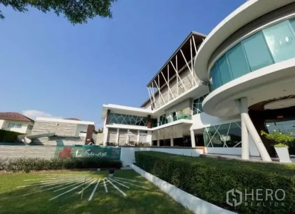 Detached House for rent in Bang Phli, Samut Prakan - Modern estate clubhouse with curved glass facade and manicured lawn.