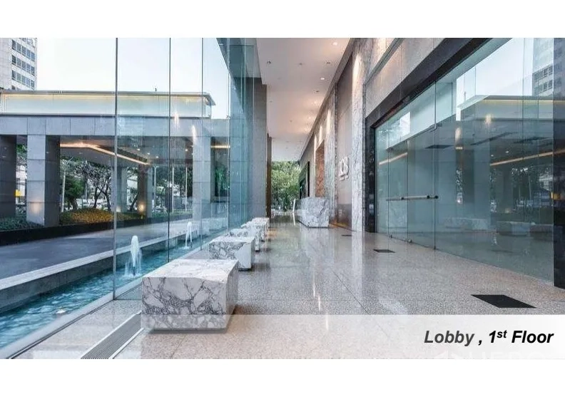 办公空间 出租在Pathum Wan, Bangkok - 一层大堂，通高玻璃幕墙、大理石座椅与线性水景。