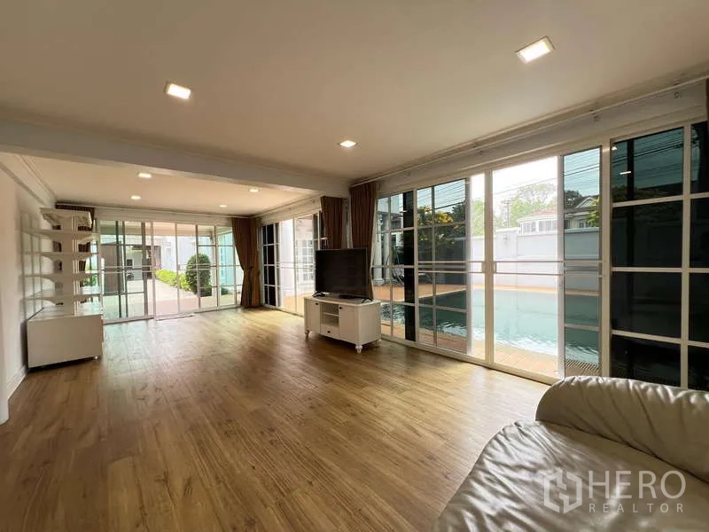 Detached House for rent in Bang Phli, Samut Prakan - Bright living area with floor-to-ceiling sliders overlooking the pool and garden.